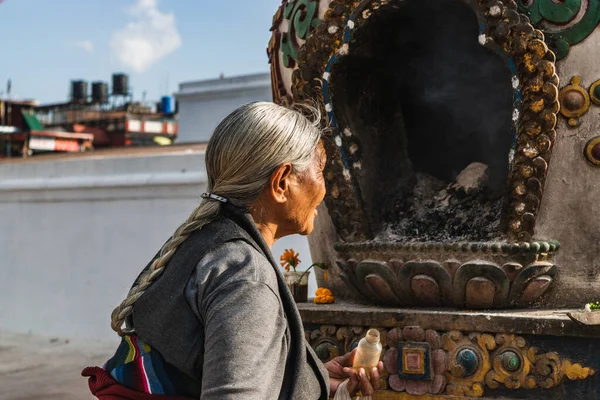 Katmandu şehrindeki Budist tapınaklarında her gün namaz kılan kadın..
