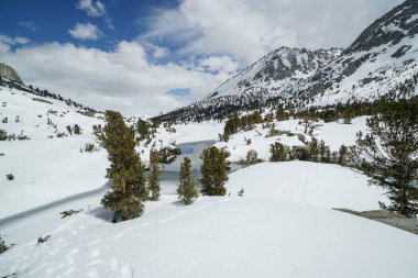 Pacific Crest Patikası. İçinden bir nehir akan karlı bir dağ sırası. Kar derin ve ağaçlar çıplak. Huzurlu ve huzurlu bir sahne.