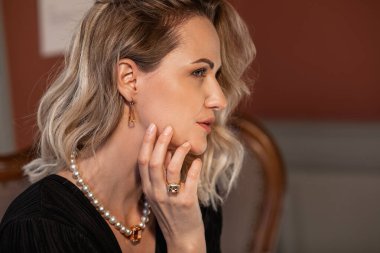 Romantic portrait of a girl dressed in an elegant dress and expensive jewelry