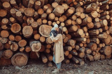Küçük bir çocuğu olan güzel bir anne göl kenarında ve parkta bir oğlan yürür. Gülümserler, sarılırlar ve doğaya hayran kalırlar..