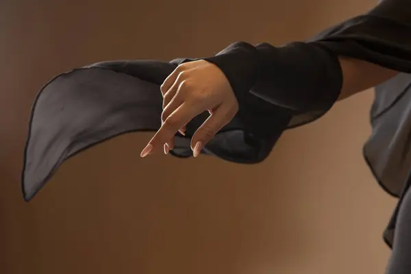 Weibliche Hand Einem Eleganten Schwarzen Flatterkleid Auf Beigem Hintergrund Studiofoto Stockbild
