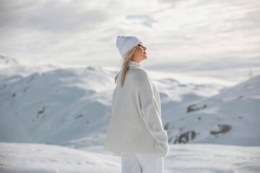 İsviçre Alpleri 'nin dağlarında güzel bir sarışın kız. Kış güneşli, çok kar var. Tatil