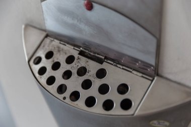 Metal saplı elektrikli ızgara ve arka planda yangın.