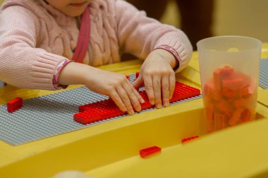 Küçük kız inşaatçıyla oynuyor..