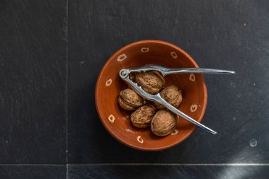 Taze ve lezzetli cevizler karanlık bir masada metal bir tabakta.