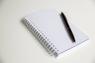 beyaz arkaplanda kalem olan dizüstü bilgisayar
