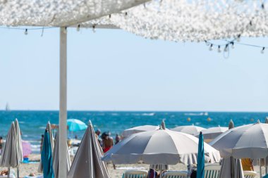 Güneşli yataklı ve şemsiyeli yaz plajı