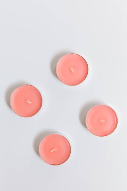 Beyaz arka planda pembe ve beyaz mumlar, düz uzanma, üst görünüm.