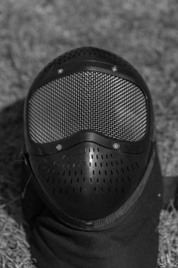 Yeşil çimlerin üzerinde siyah bir maske