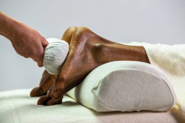 Masaj taşlarıyla kadın ellerine yakın çekim.