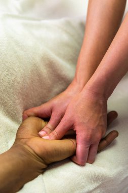 Bir hastaya masaj yapan bir kadının ellerini kapat.