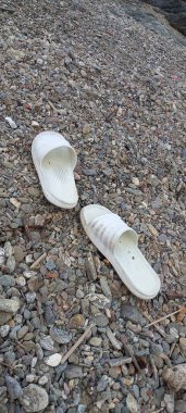 Kumda beyaz ve gri lastik ayakkabılar