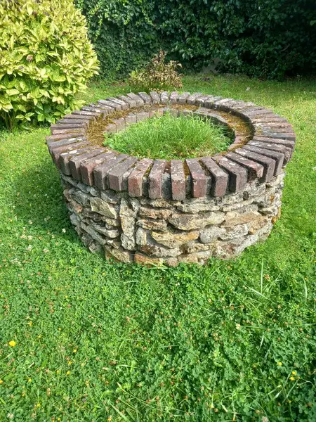 stock image old brick wall with green grass and grass