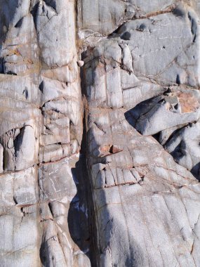 Çatlakları ve çizikleri olan taş bir duvarın dokusu arka plan olarak kullanılabilir.