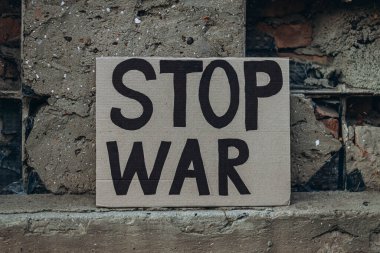 Ukrayna 'da pankartla yapılan savaşa karşı yapılan protestolarda yazılı mesaj DUR SAVAŞ metni, şehir arkaplanı mahvoldu. Kriz, barış, Rus saldırı konsepti. Savaş karşıtı gösteri..