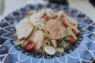 Restorandaki masada farklı marul, tavuk, peynir ve domatesli sağlıklı salata tabağı. Izgara tavuk göğsü ve taze sebzeler.