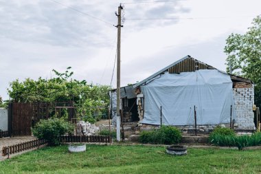 Bilozirka, Ukrayna - 26 Mart 2023: Rusya Ukrayna 'ya karşı savaş. Bomba patlamasından sonra köydeki eve zarar verildi ve yok edildi. Binadaki delikler. Malzeme harabeleri. Yıkım