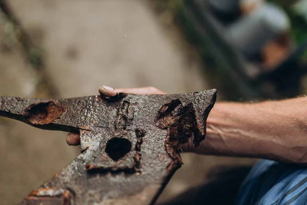 stock image Bilozirka, Ukraine - March 26, 2023: The man holds damaged and destroyed, full of holes piece of metal after the bomb explosion. Russia destroyed small village for 8 month. The war against Ukraine.