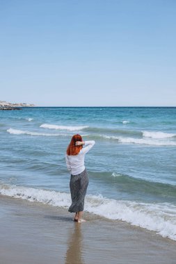 Kaygısız genç turist kadın deniz kenarında yürüyor ve deniz manzarasının tadını çıkarıyor. Yaz tatili yurt dışında. Mutluluk, ürpertici konsept. Seyahat ediyorum. Akdeniz yakınlarındaki popüler İspanyol tatil beldesi