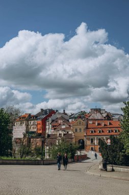 Lublin, Poland- 10 Mayıs 2023: Lublin Kalesi 'nin Neo-gotik bölümünün ana giriş kapısından şehre bakın. Ortaçağ yenilenmiş binalar, güneşli baharda mimari.