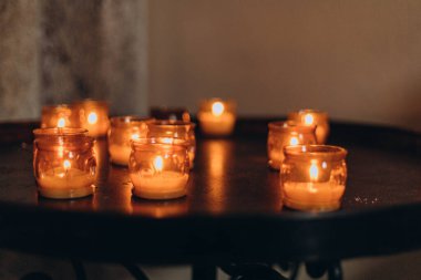 Paskalya mumlarının gece yanan altın mum ışığının resmi. Karanlık bir kilisede parlayan Lampion mumları. Duygusal bir ruh hali. Çok sayıda yanan mum sığ alan derinliğinde