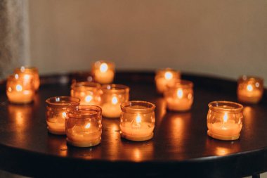Paskalya mumlarının gece yanan altın mum ışığının resmi. Karanlık bir kilisede parlayan Lampion mumları. Duygusal bir ruh hali. Çok sayıda yanan mum sığ alan derinliğinde