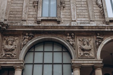 Milan, Italy- 13 Mayıs 2023 Gotik mimari ve beyaz mermer heykeller. Milano, Lombardia, İtalya 'daki bir numaralı turistik ilgi merkezi. Ortaçağ mimari elementleri, antik kemerler, sütunlar