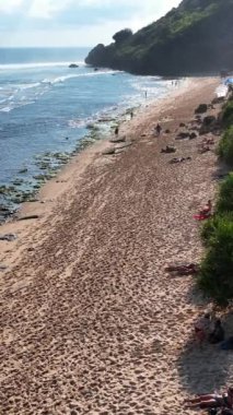 Sahilin güzel bir sahili, kumlu bir sahili ve Nyang Nyang Beach Bali 'deki insanları. Deniz kıyısında. Yaz tatilleri, lüks tatil manzaraları, çarpıcı okyanus gölleri. Kumsalda dinlenirken.