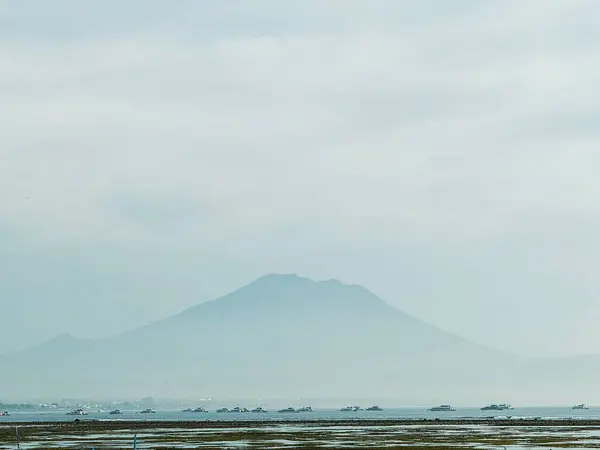 Bir dağ ve plajı olan güzel bir manzara.