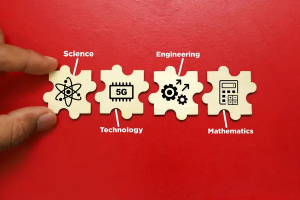 İnsan eli bulmaca parçalarını bilim, teknoloji, mühendislik ve matematik simgeleriyle tutuyor.
