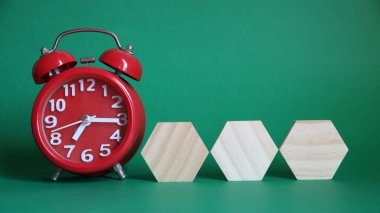 Yeşil arkaplanda tahta saat ve bloklar