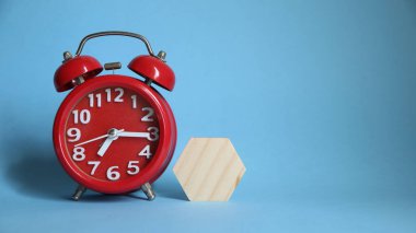 Mavi zemin üzerinde tahta küpleri olan kırmızı alarm saati