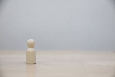 Beyaz arkaplanda tek başına duran tahta bir figür ve kopyalama alanı