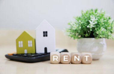 Model ev hesap makinesi ve çıkartma metni Rent 'e yerleştirildi. Evin kırmızı bir çatısı var, görsel olarak mülk kiralama kavramını temsil ediyor. 
