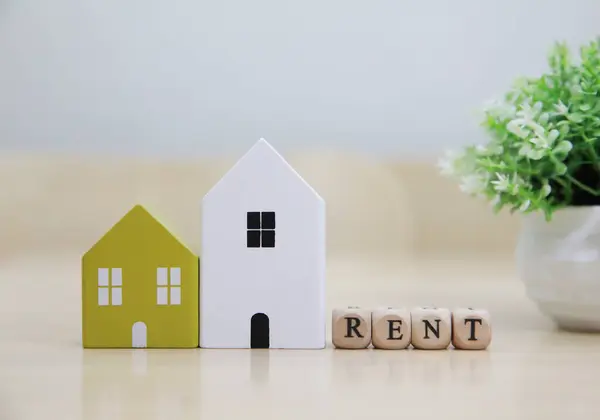Model ev hesap makinesi ve çıkartma metni Rent 'e yerleştirildi. Evin kırmızı bir çatısı var, görsel olarak mülk kiralama kavramını temsil ediyor.