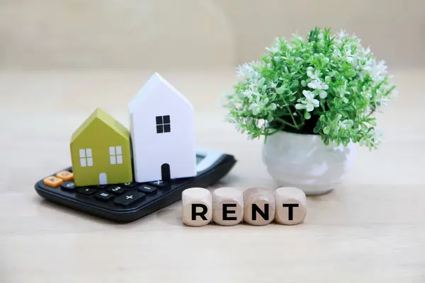 Model ev hesap makinesi ve çıkartma metni Rent 'e yerleştirildi. Evin kırmızı bir çatısı var, görsel olarak mülk kiralama kavramını temsil ediyor. 