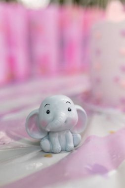 Küçük bir kızın doğum günü için pembe desenli güzel bir pasta. Çikolata. Bebek partisi. Filli cinsiyet partisi teması. Pasta ve kalplerle şenlikli arka plan dekorasyonu.