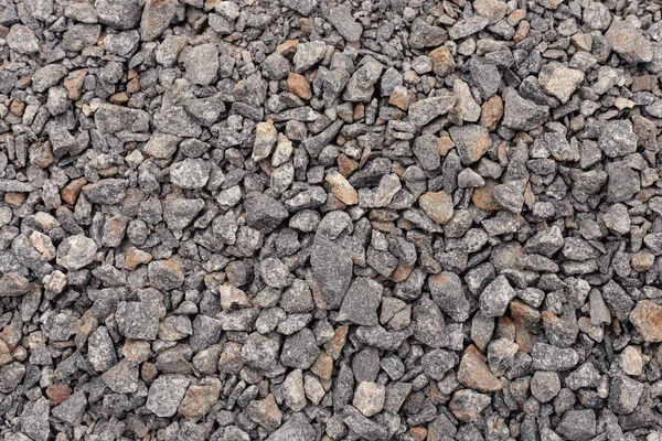 Crushed stone close up. Crushed stone construction materials. Small stones ground. Small stone construction material. Background, texture of stones.