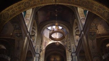Kilisenin içinde kamera hareketi. Eski Katedral, Hristiyan Ortodoks Kilisesi. İç duvar resimlerinin içinde ikonlar olan eski tarihi bir bina. Yavaş çekim.