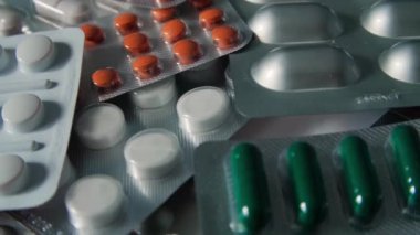 Tıbbi ilaçlı pakete yakından bak. Haplar ve uyuşturucular. İlaçlar, haplar ve su toplayan haplar. Farklı haplara yakın çekim. Yavaş çekim.