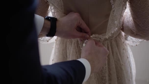 Der Bräutigam Befestigt Das Kleid Der Braut Nahaufnahme Der Hände — Stockvideo