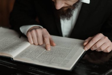 Tevrat okuyan bir adamın yakın çekimi. Kitaba yakın çekim yapın. Tevrat 'ı okuyorum. Kitap okuyan bir adamın elleri, yakın plan..