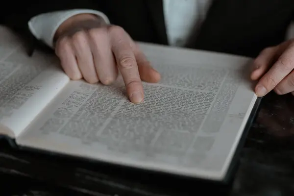 Close-up of man reading the Torah. Close-up of hands on book. Reading the Torah. Hands of a man reading a book, close-up.