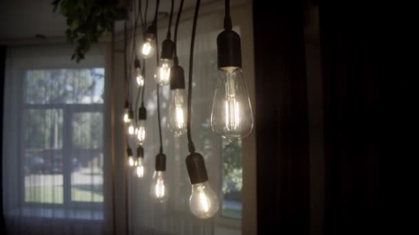 部屋のレトロな電球をスウェーディング 古いランプホルダーが付いているアンティーク電球は入れられます 暗い部屋に紐づけられた電球のグループ — ストック動画