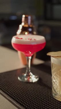 Canlı renklerde üç farklı karışım kokteyli. Barda çeşitli kokteyller var. Dikey video.