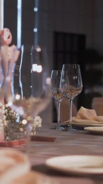 Bir restoranda tatil için masa servisi yaptım. Bardaklar, tabaklar, çatal bıçak takımı, peçeteler. Düğün yemeği servisi, evde resepsiyon. Garson restoranda bir masa servisi yapıyor. Dikey video.