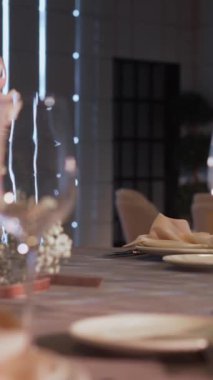 Bir restoranda tatil için masa servisi yaptım. Bardaklar, tabaklar, çatal bıçak takımı, peçeteler. Düğün yemeği servisi, evde resepsiyon. Garson restoranda bir masa servisi yapıyor. Dikey video.