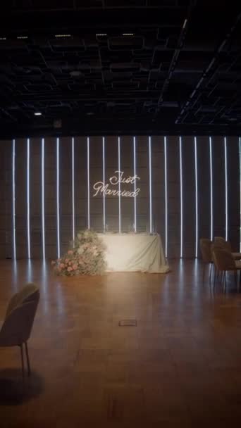 婚礼桌上时尚的装饰 霓虹灯领着 的标志 桌上摆满了粉色和米黄色的婚花 用浅色装饰的婚桌 垂直录像 — 图库视频影像
