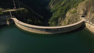 Romanya 'daki Vidraru barajının hava görüntüleri. Video, Vidraru Gölü 'nün yukarısındaki barajdan çekilmiş. Kamera aşağı eğilmiş ve göl ve barajın en üst görüntüsü için sola yatmış..