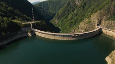 Romanya 'daki Vidraru barajının hava görüntüleri. Video, Vidraru Gölü 'nün yukarısındaki barajdan çekilmiş. Kamera aşağı eğilmiş ve göl ve barajın en üst görüntüsü için öne doğru uçuyormuş..